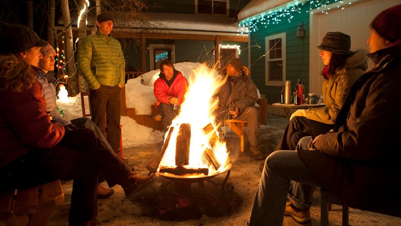 A group of friends around a bonfire during winter. 
