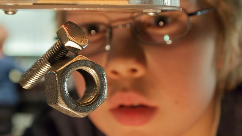 A young boy looking at levitating iron bolts in a strong magnetic field. 