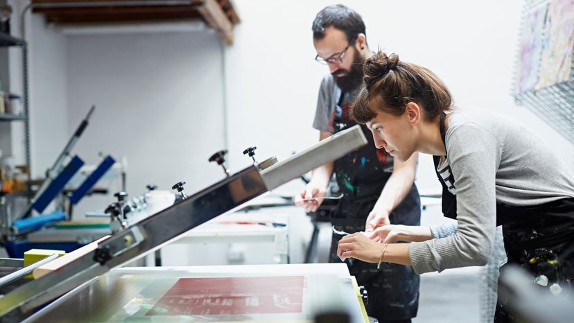 A female worker inspecting a printed piece. 