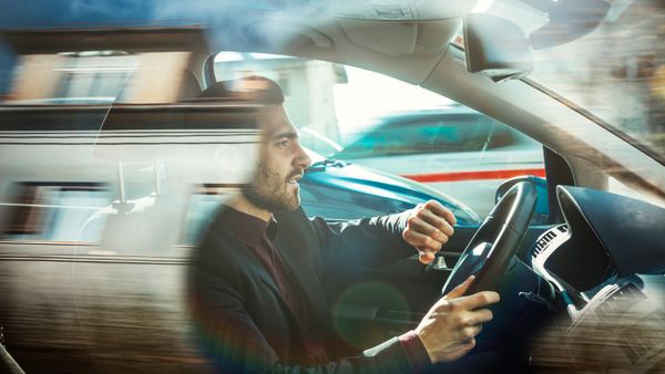 Businessman driving car alone.