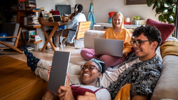 A close up of a young adults spending time together, watching something on a tablet. 