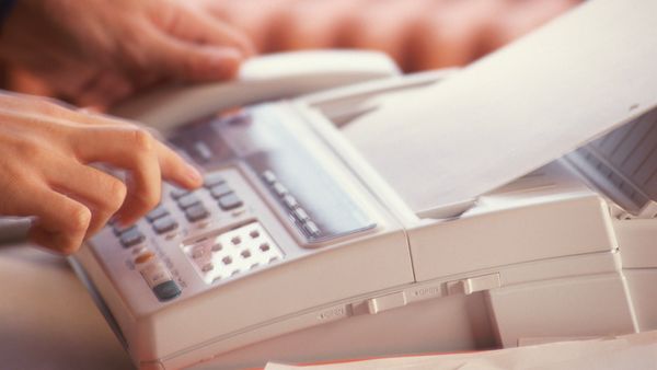 A man using a fax machine. 