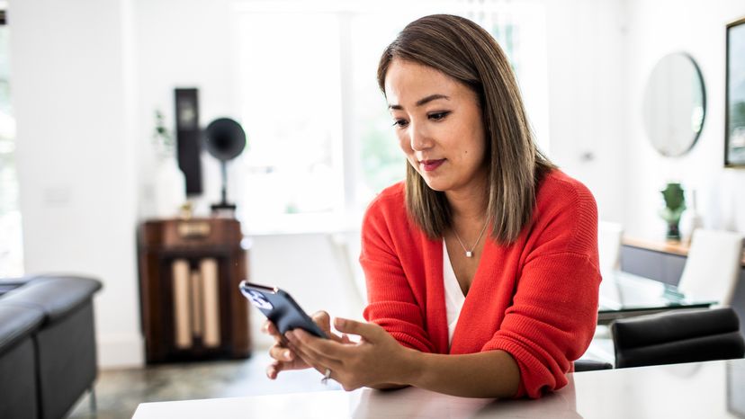 A woman using her mobile phone at home. 