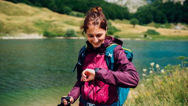 A female hiker looking at her GPS watch. 