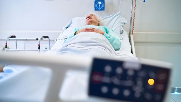 A patient lying on a gurney in a hospital ward. 