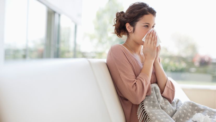 A sick lady sitting on a couch. 