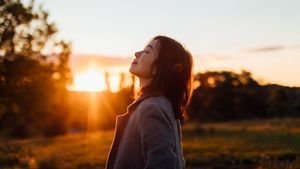 An Asian woman receiving a breath of fresh air.