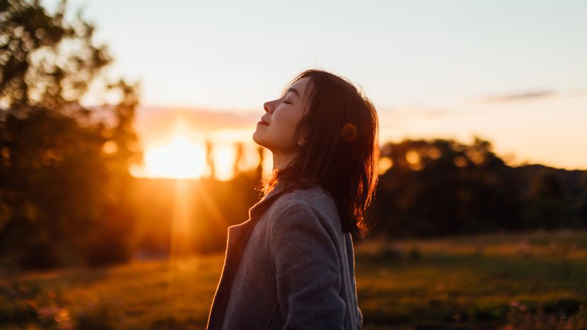 一个亚洲女人接受呼吸新鲜空气。”width=