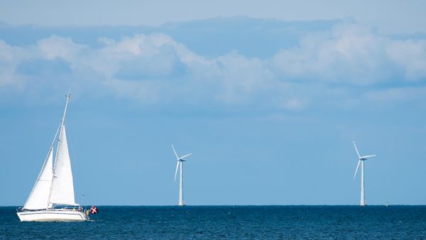 An offshore wind turbine and sailing boat. 