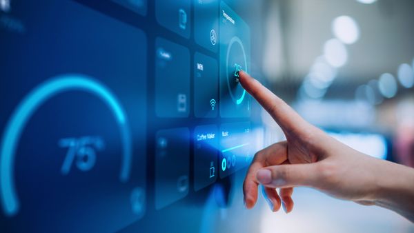 A close up of a woman using her intelligent home system to control appliances in the house. 