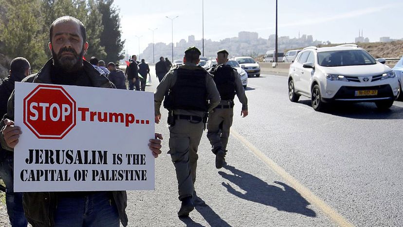 A Palestinian protester holds a placard during a demonstration against the construction of Jewish settlements in the occupied West Bank and against President Donald Trump.
 BBAS MOMANI/AFP/Getty Images
