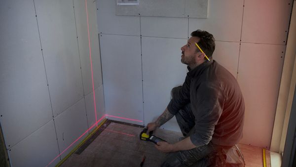 A man making use of a laser measuring tape.