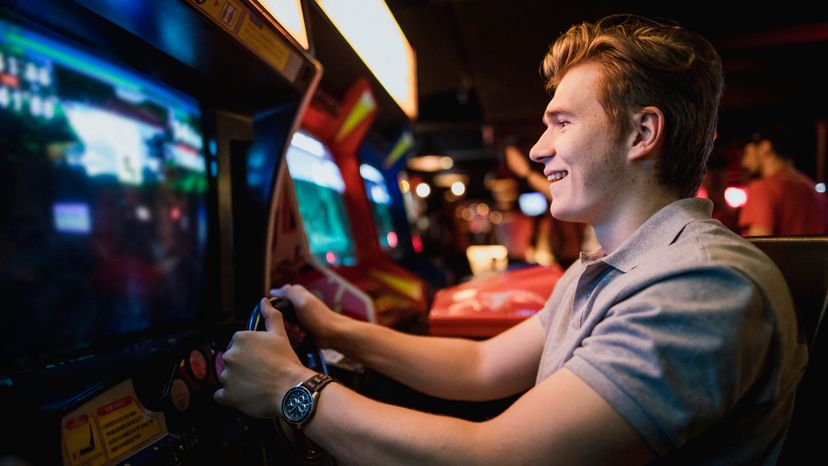 A young man playing games at an arcade. 