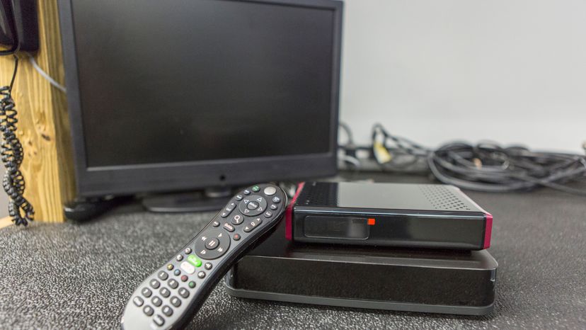 A TV remote in front a computer monitor.