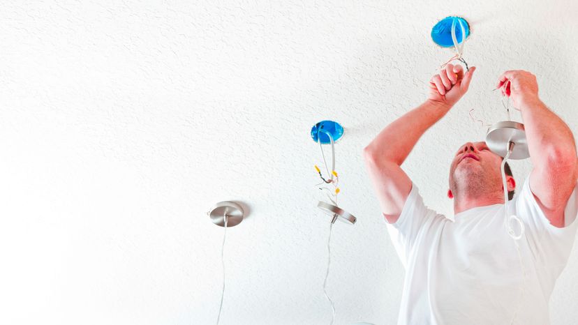 An electrician hanging fixtures.