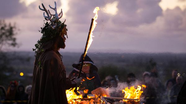 Men outdoors marveling at natural flame fire.