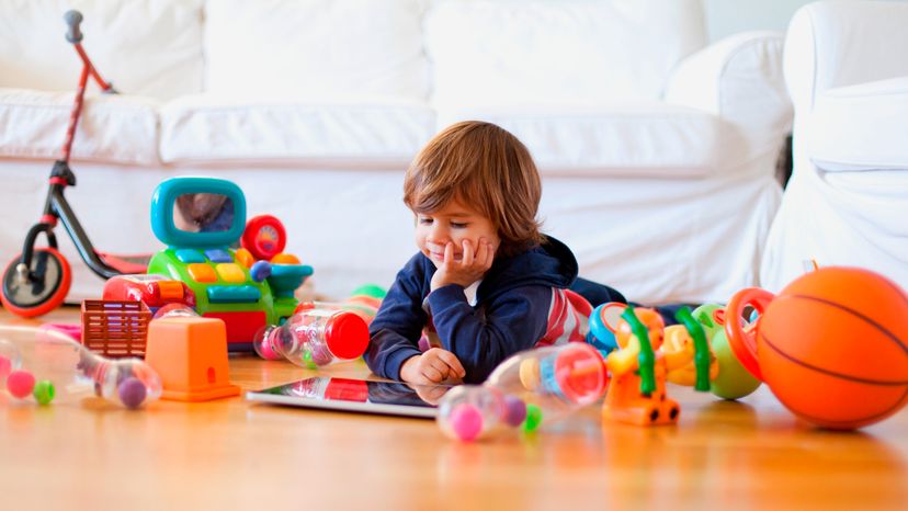 A child with toys all around him. 