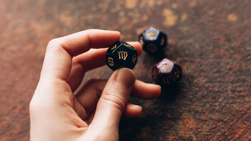 a female hand holding an astrological cube with the Virgo sign. 