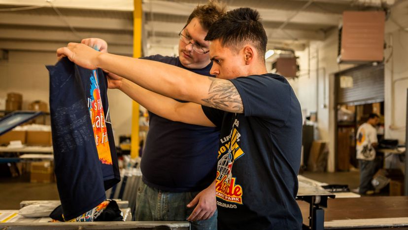 Two men looking at a T-shirt design. 