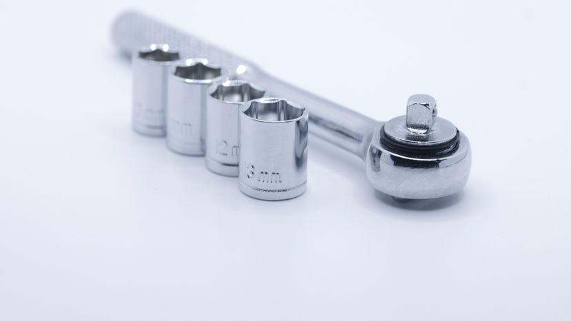 A socket wrench with different socket sizes on a white background. 