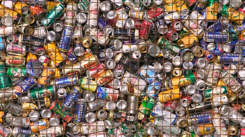 Different kinds of soda cans on a floor. 