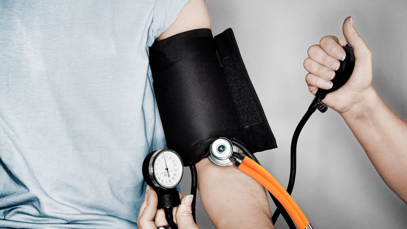 A nurse checking the blood pressure of a patient.