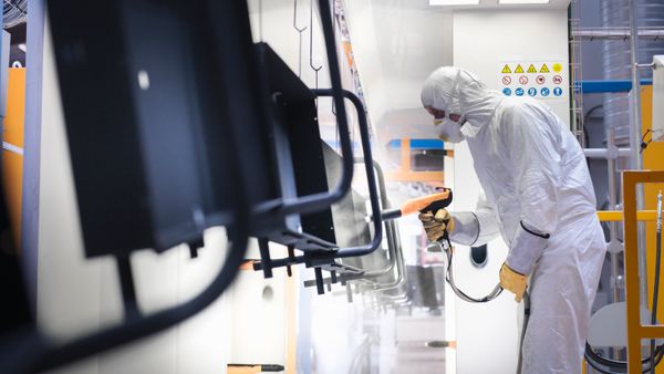 An image of a man spraying powder coating.