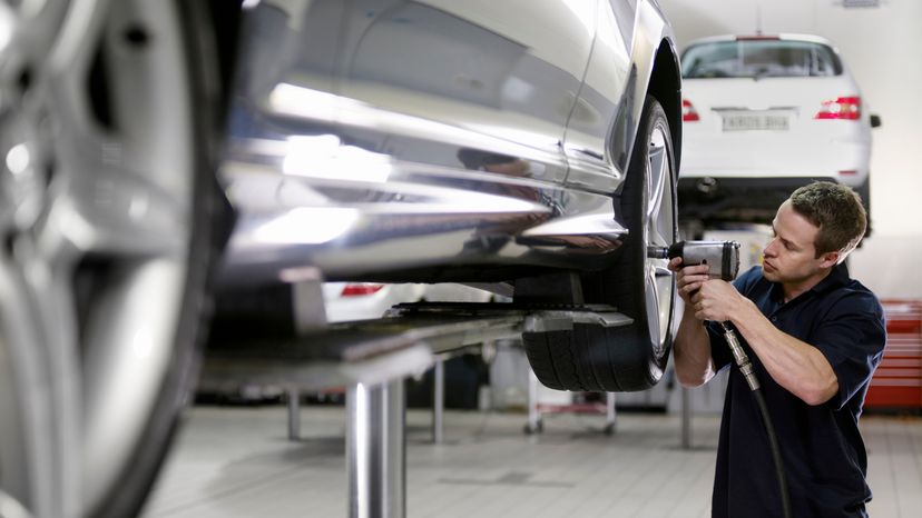 A man fixing a cars tire. 