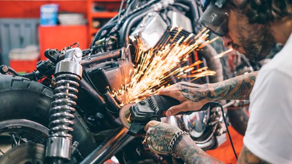 A motorcycle mechanic working on a bike. 