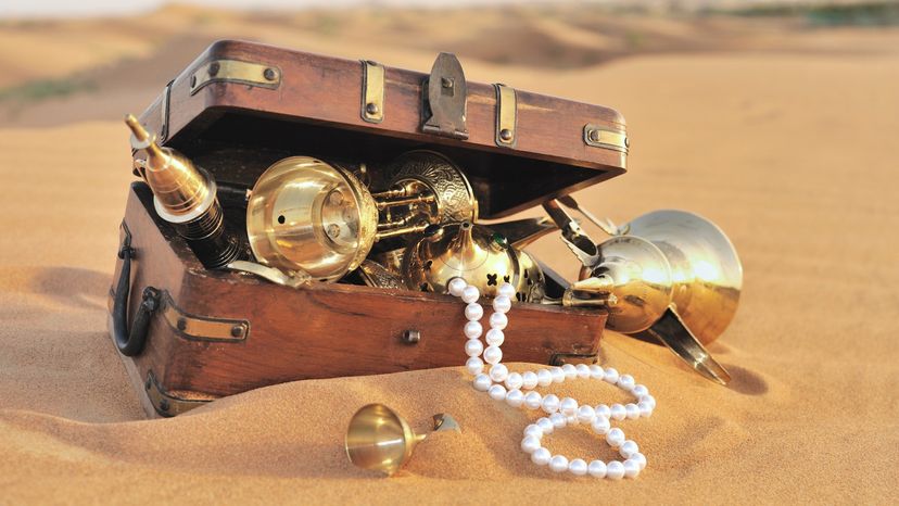 A treasure chest filled with treasure in the middle of a desert