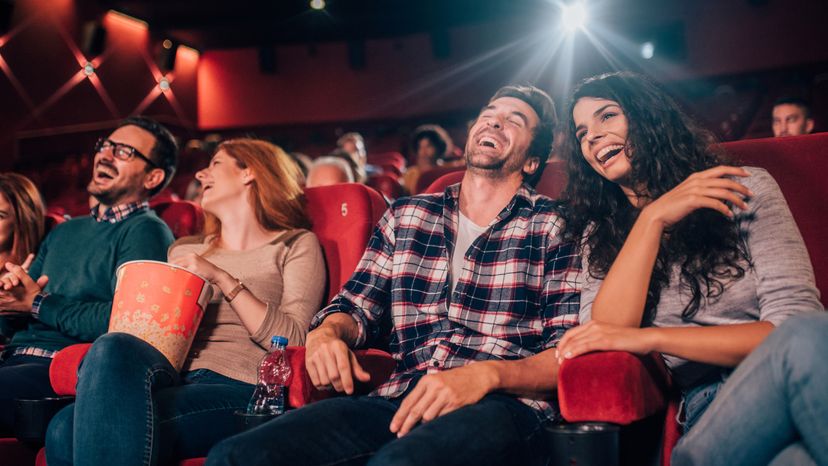 Four friends laughing in a cinema.