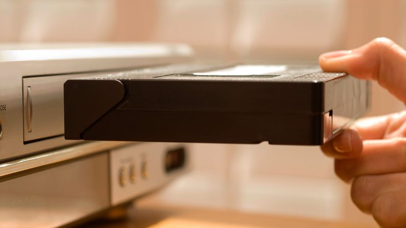 A man loading a vhs tape. 