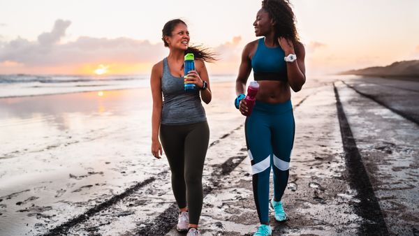 Two women in sport wears walking down a walkway. 