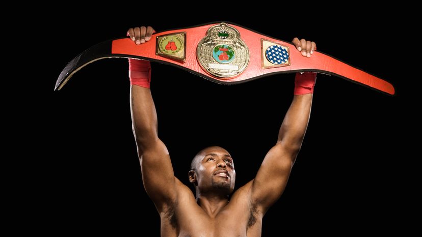 男性的拳击冠军, holding up his championship belt.