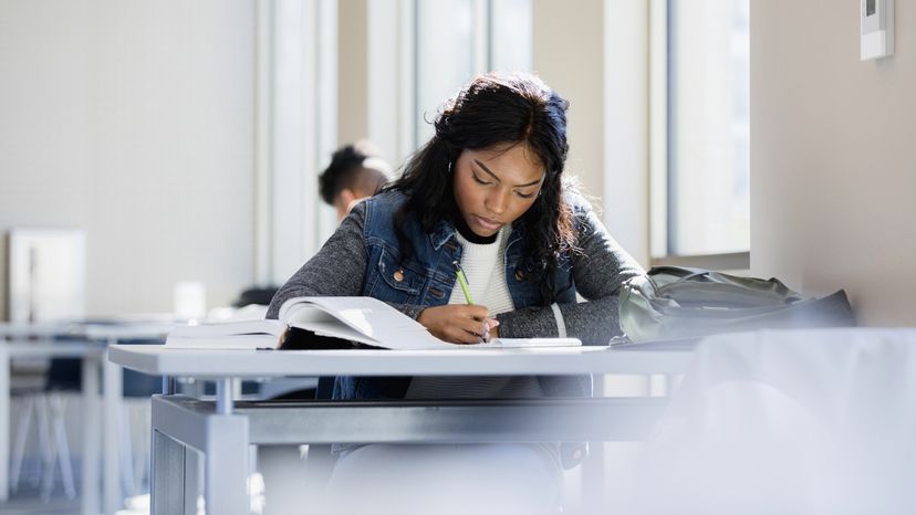 A young woman reading a textbook. 