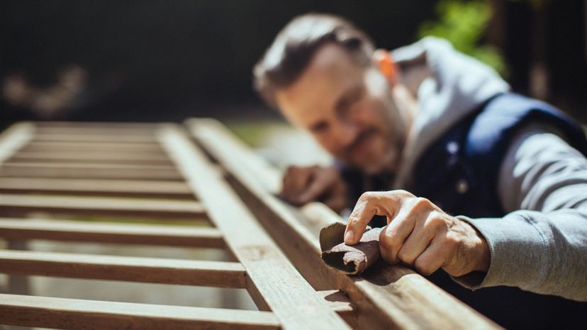 A man grinding an old handrail. 