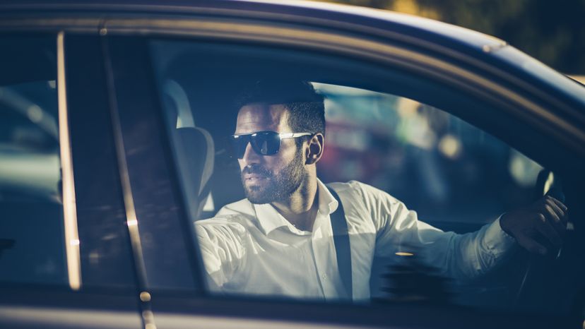 A man driving a car in reverse.