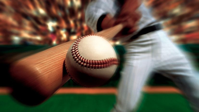 A baseball player using his bat to hit a homerun. 