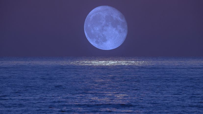 An image of the moon over the ocean. 