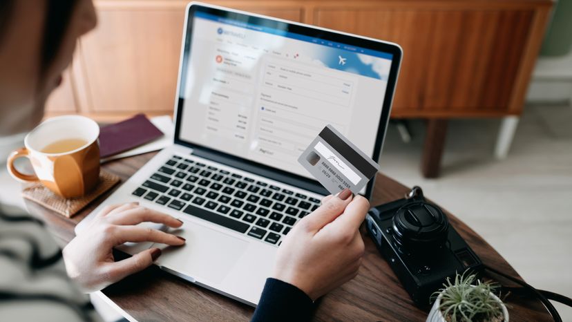 A woman using her card to pay for plane tickets online. 