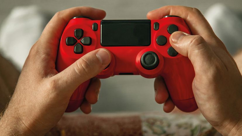 Photo of a man holding a red gamepad. 