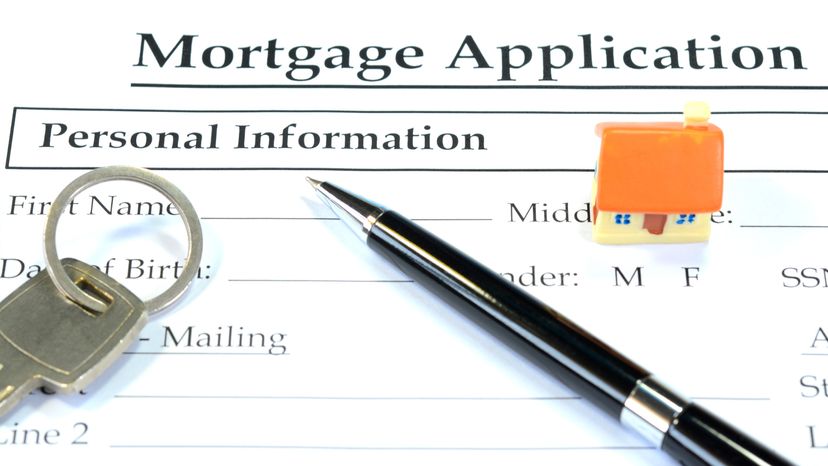 Filling up a blank mortgage Application form with a pen.