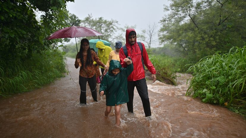 A group of people walking in flood water.