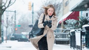 Woman embracing winter's snow outdoors.