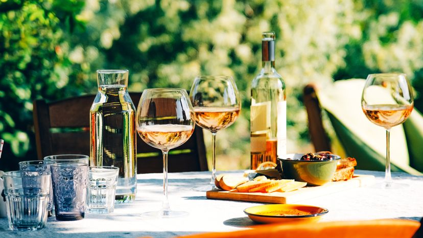 A wine glass, bottle and appetizer on a table. 