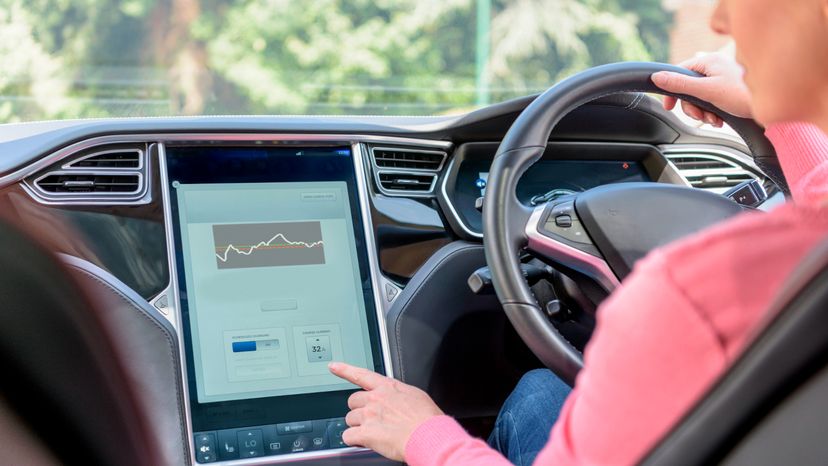 A woman using the navigation system in her car. 