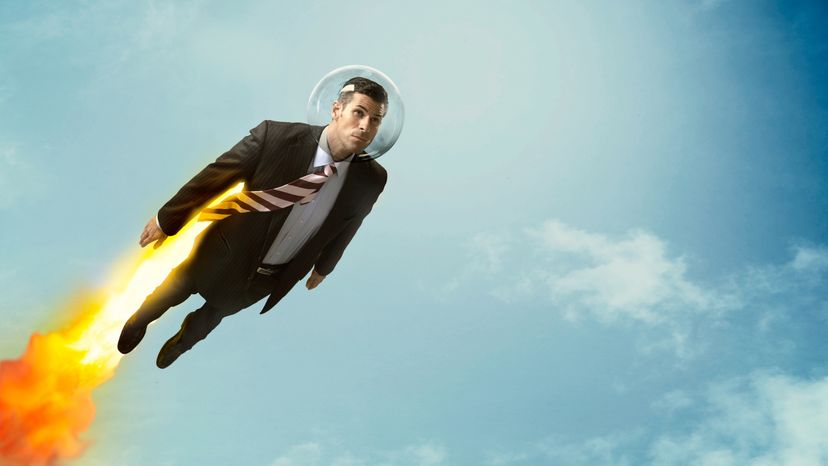 A man wearing suit and flying through the sky with a jetpack. 