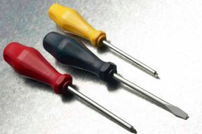 You'll want a variety of screwdrivers in your tool box. The flathead (depicted in the middle) is used for screws that have one slot across. The Phillips (pictured on the ends) works with screws that have cross-shaped tips.