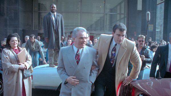 Businessman in suit outdoors near car.