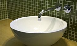 A modern bathroom with a white porcelain bowl sink.